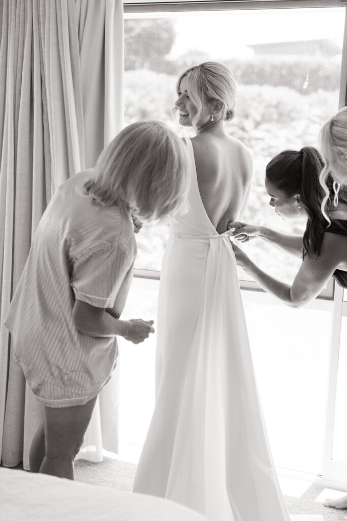 Bridesmaids helping with dress