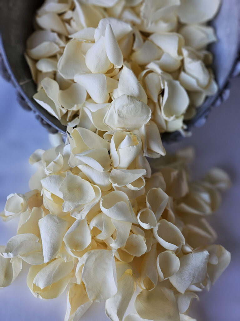 white-rose-petals-spilling-out-of-silver-bucket.jpg