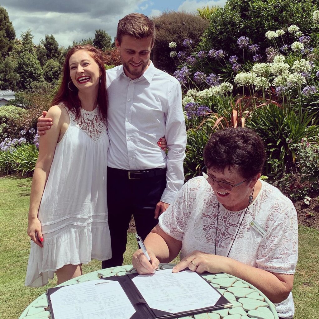 Tauranga-celebrant-Debbie-sings-license-with-happy-couple.jpg